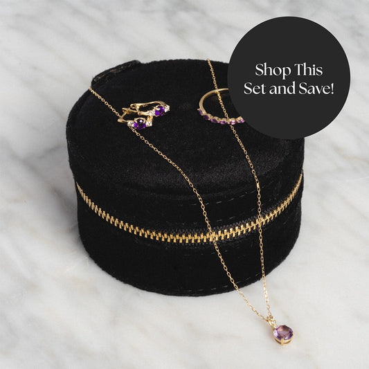 The Solid Gold 2025 February Capsule Amethyst Stacking Set with Free Gift is displayed on a black velvet case. A black circle reads, Shop This Set and Save!.
