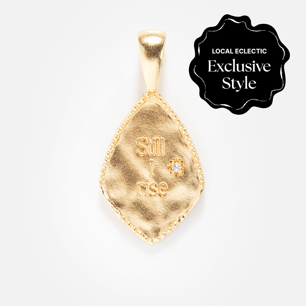 Charms by Joy Dravecky: A 14k gold plated pendant engraved with Still I rise and a small gem, paired with a black scalloped label reading LOCAL ECLECTIC Exclusive Style, adds meaningful charm to your collection.