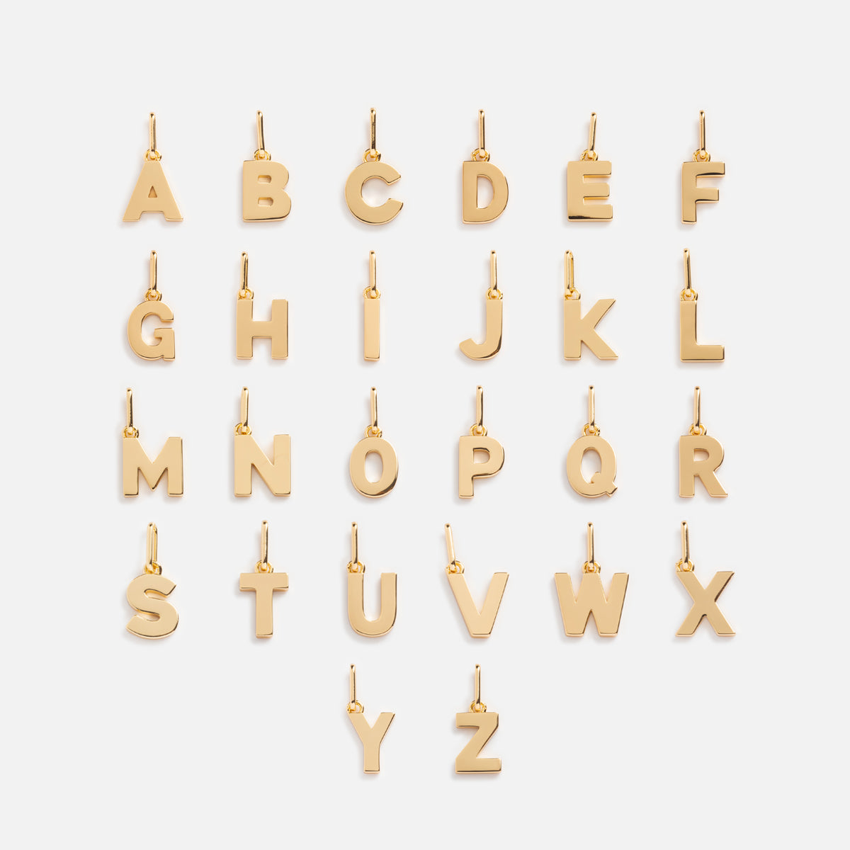 The Be You Initial Charm collection features 26 gold charms, one for each letter from A to Z, displayed in four neat rows on a white background—ideal for creating your own personalized necklace or jewelry.