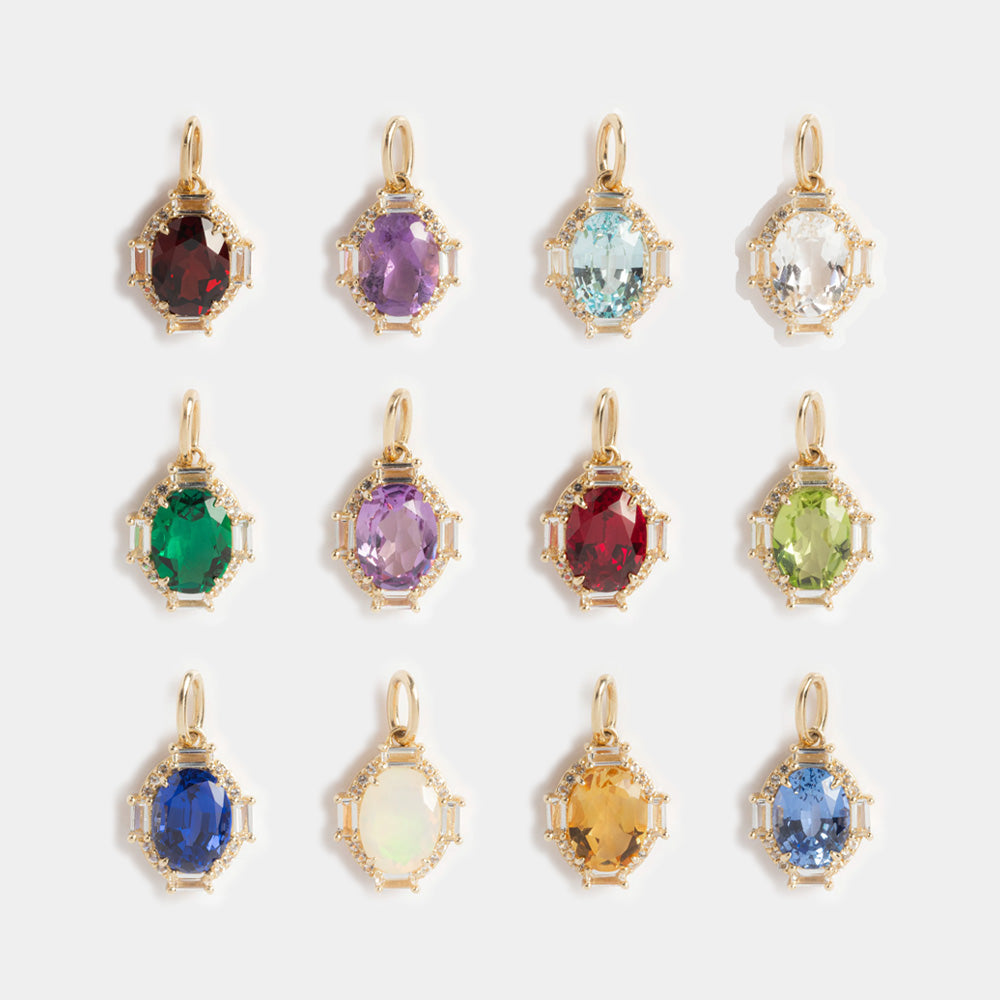 Twelve Solid Gold Vintage Inspired Birthstone Charms in vibrant red, purple, blue, green, yellow, and clear hues. Each charm features a unique faceted stone and gold frame, arranged in three rows.