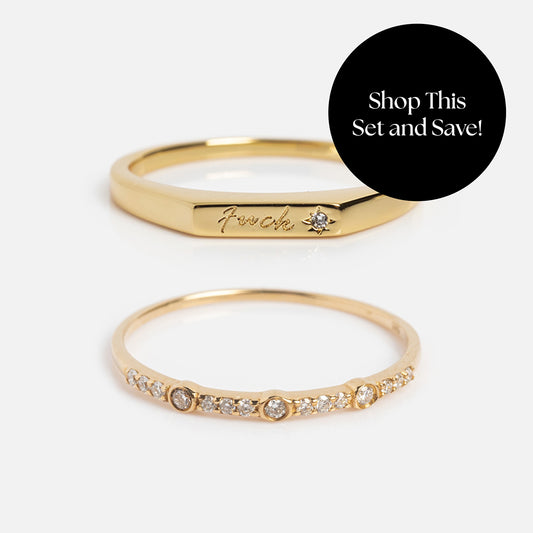 Two gold rings: one engraved with F*ck and set with a tiny sapphire, the other a thin band featuring small sapphires. A black circle reads, Shop This Set and Save! Product: Solid Gold Tiny Fuck Sapphire Stacking Ring Set.