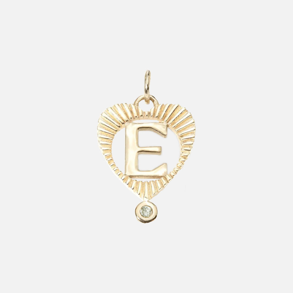 The Sunbeam Letter Heart Charm is a 10k gold heart pendant with a textured edge, featuring an E and a small round gemstone—an ideal birthstone necklace and personalized gift.
