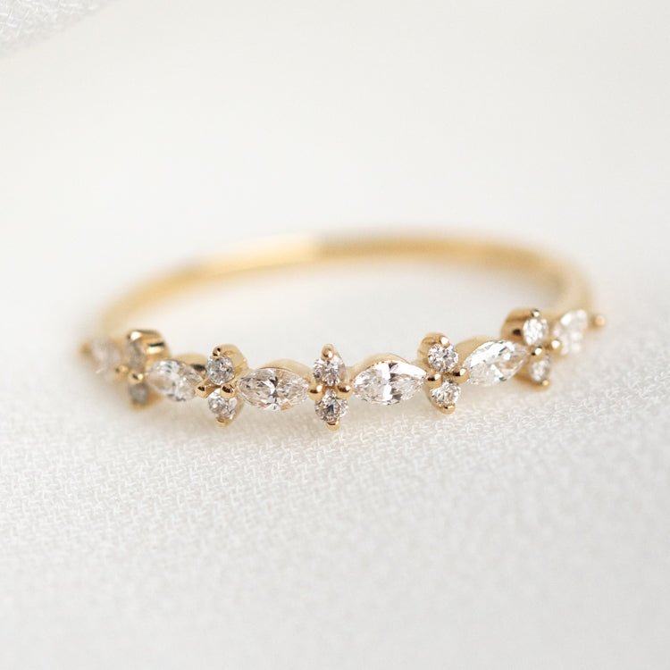 The 14k Luxe Diamond Celebration Band Sample Size 7 features alternating marquise and round-cut diamonds in a floral design, elegantly displayed on a soft, light-colored fabric background.