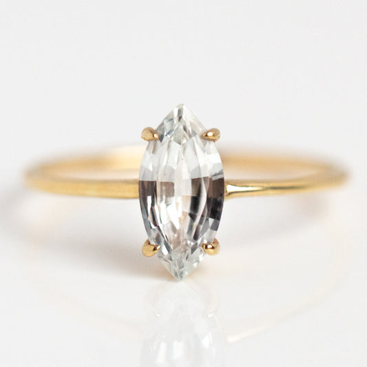 The Solid Gold Gemstone Marquise Ring in White Topaz showcases a clear marquise-cut gemstone solitaire set with four prongs, displayed on a white background.