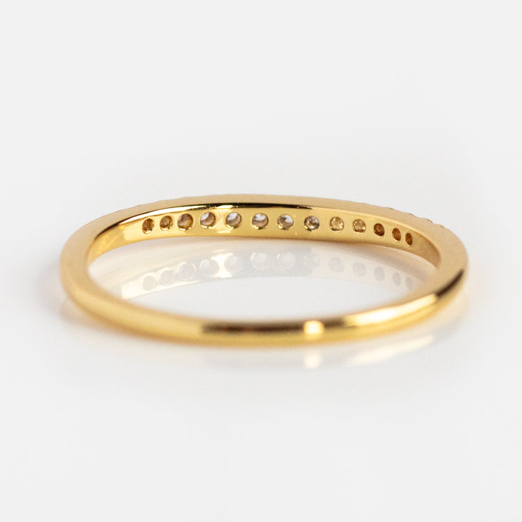 The Renaissance Curved Stacking Ring features a thin 14k yellow gold plated band with small, evenly spaced round holes on one side, displayed against a white background.