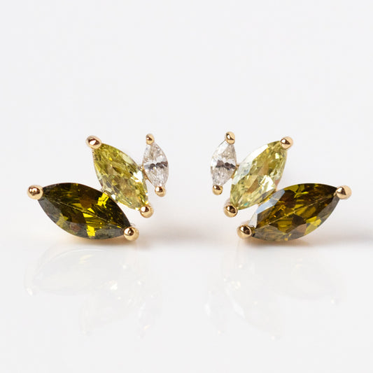 The Peaceful Green Petal Studs are gold earrings featuring three marquise-cut stones in ombre green and yellow, plus one clear marquise stone, arranged in a clustered design on a white background.