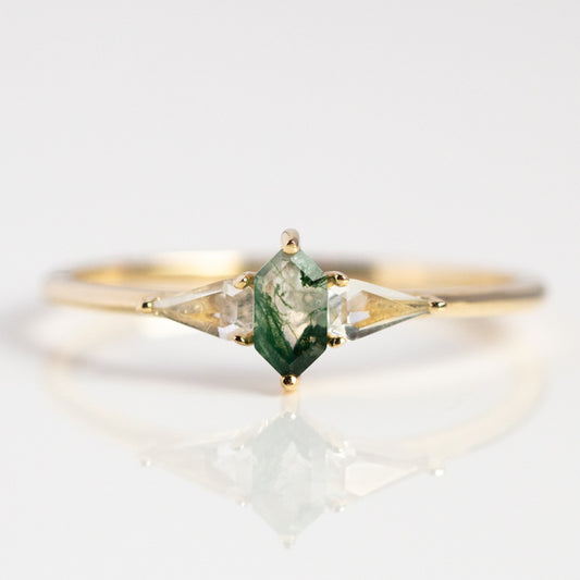 The Solid Gold Aquatic Agate Elements Hexagon Ring features a geometric hexagonal moss agate center and two clear triangular gems, creating an elegant, unique jewelry piece displayed on a white background.