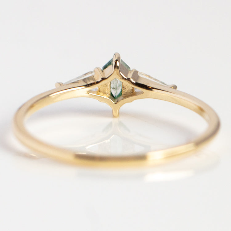 The Solid Gold Aquatic Agate Elements Hexagon Ring features a green marquise-cut gemstone at the center with two clear triangular stones, elegantly showcased from a side angle on a white surface—perfect for agate jewelry lovers.