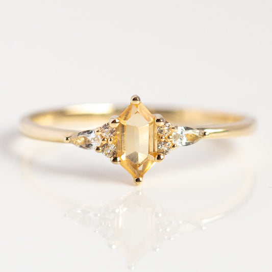 The Solid Gold Citrine Destiny Hexagon Ring for Abundance showcases a hexagon citrine center and two clear side stones, embodying Harvest Moon inspiration on a white background.
