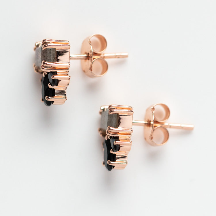 The Gemstone Empress Stud Earrings feature black gemstones in a rose gold prong setting with butterfly backings, shown from the side against a white background.