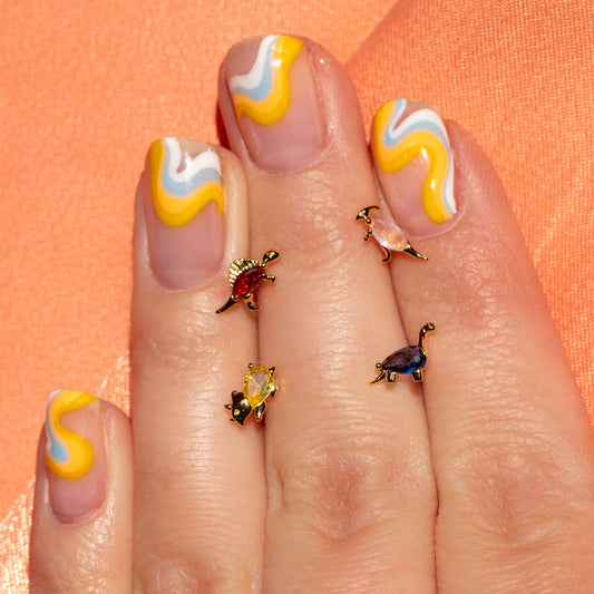 dinosaur studs between fingers with colorful nail art