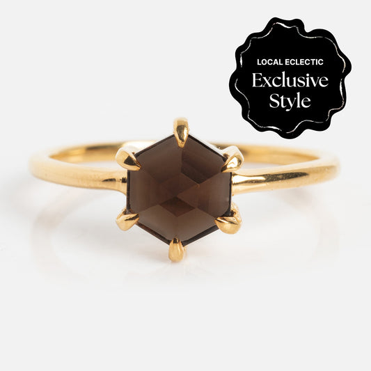 The Hexagon Smokey Quartz Ring in 14k gold vermeil features a dark gemstone set with six prongs. A black label reads “Local Eclectic Exclusive Style.” Ideal for fans of vintage-inspired jewelry.