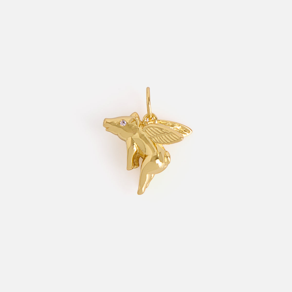 A small, shiny gold “Charms by Mod and Jo” pendant shaped like a flying pig with detailed wings and a tiny gemstone eye, photographed against a plain white background.