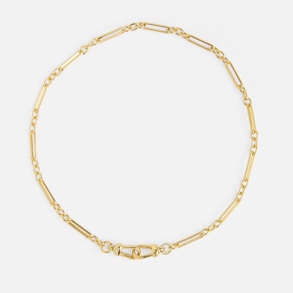 The Liam Watch Chain Charm Holder Necklace features a delicate gold chain with elongated rectangular links and a lobster clasp, shown arranged in a circular shape against a white background.
