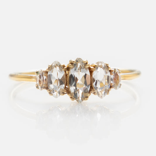 The Solid Gold Essential Marquise Cluster Ring features five clear gemstones set in a row on a delicate band with intricate prong settings, exuding heirloom quality and showcased on a white background.