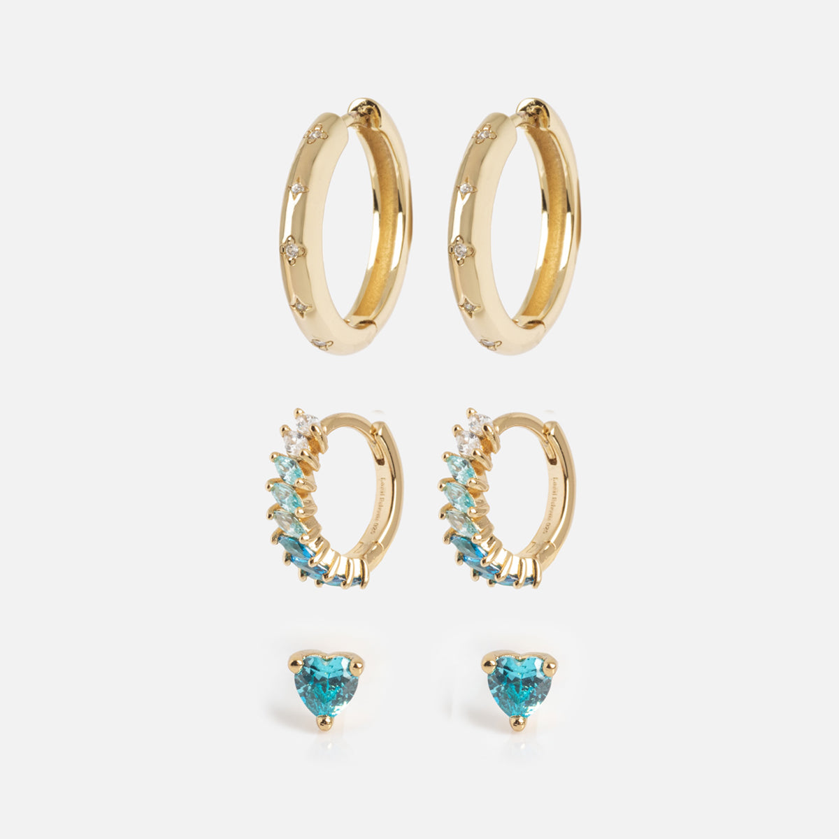 The Bold Birthstone Earring Set features three pairs: gold hoops with small diamonds, gold hoops with blue marquise-cut stones, and heart-shaped blue gemstone studs, all arranged vertically on a white background.