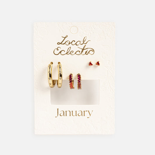 The Bold Birthstone Earring Set features gold plated hoops, small gold hoops with pink stones, and tiny pink gemstone studs on a white textured jewelry card.