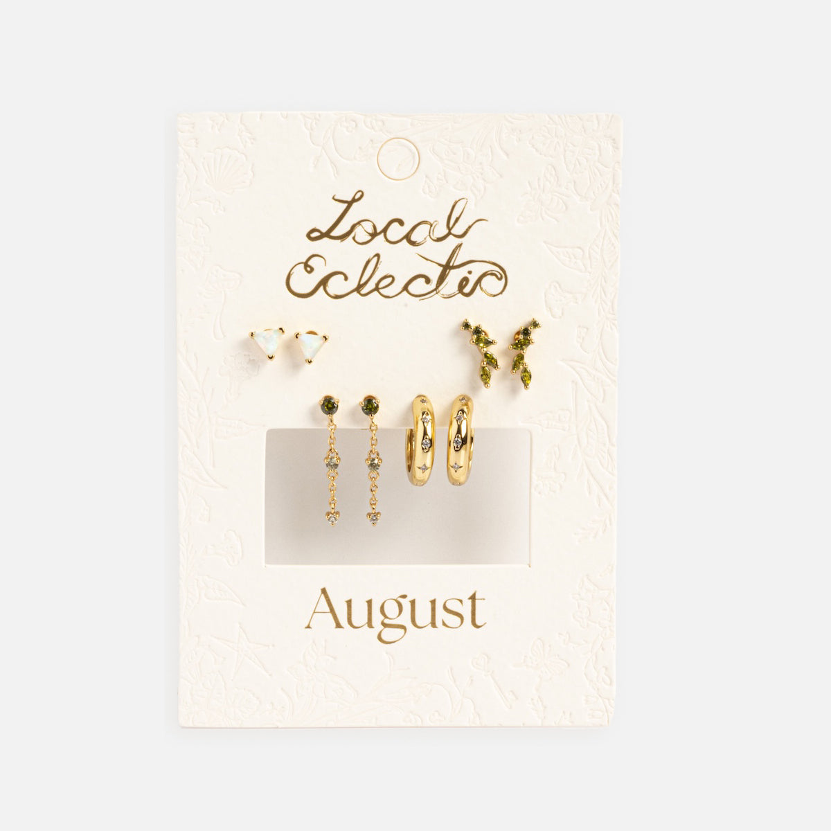 The Classic Birthstone Earring Set features six 14k gold plated earrings with green gemstones—studs, hoops, and dangles—arranged on a white Local Eclectic x August card for a personalized ear stack.