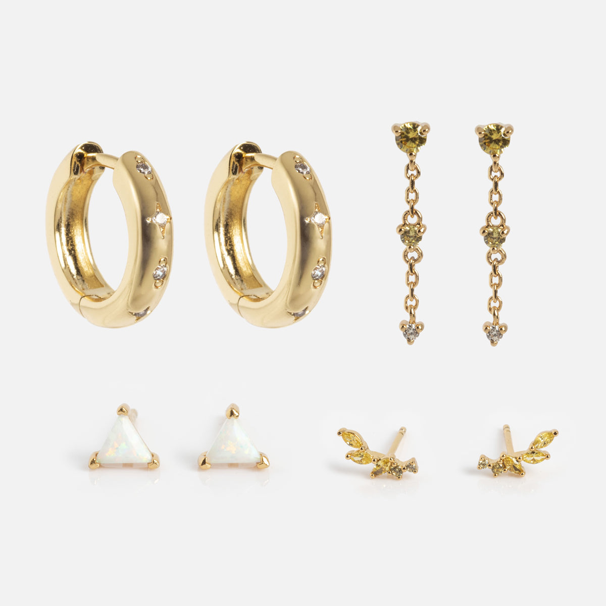 The Bold Birthstone Earring Set includes five pairs: gem-accented gold hoops, three-stone dangles, triangular opal studs, and two uniquely designed small gold stud earrings, all displayed on a white background.
