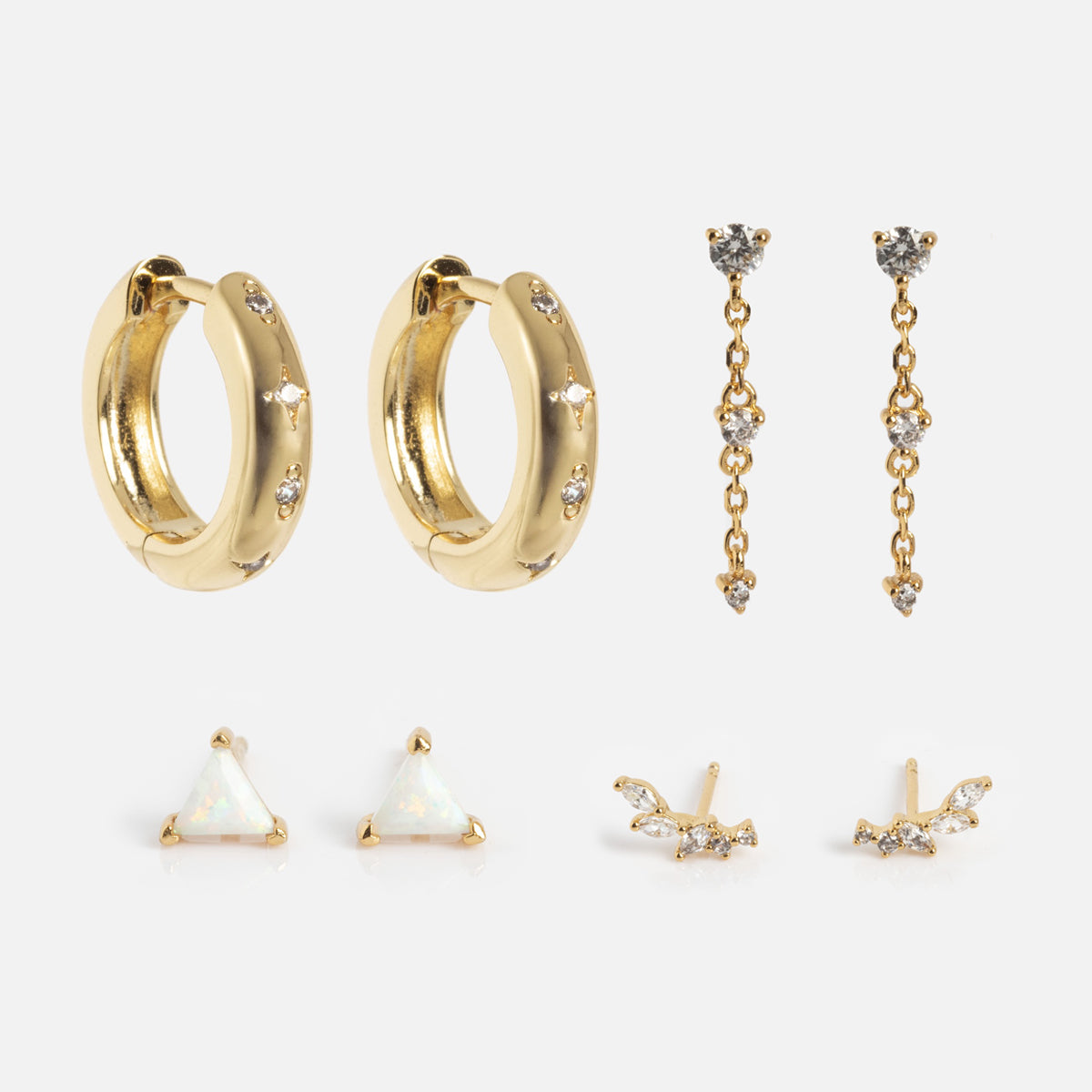 The Bold Birthstone Earring Set features four pairs: gold hoop earrings with gems, dangling linked gemstone earrings, triangular opal studs, and branch-shaped studs with gems on a white background.