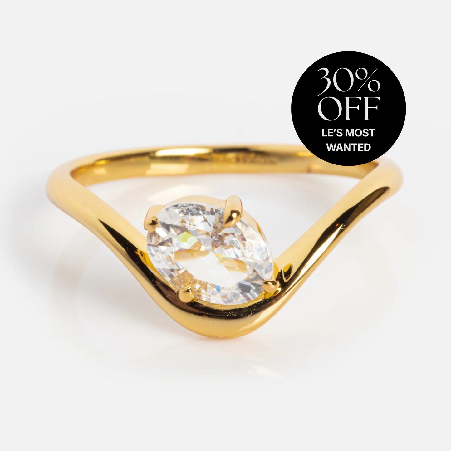 The Floating Gem Ring from Local Eclectic showcases a marquise-cut clear gem in a 14k yellow gold plated band on a white background, with a black circle at the top right reading “30% OFF LES MOST WANTED.”.