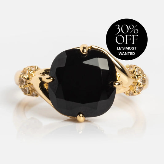 The Past Life Black Spinel Statement Ring features a large faceted black stone at the center and small clear stones on the band, shown with a sticker reading "30% OFF LES MOST WANTED.