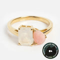 The Solid Gold Toi et Moi Colorful Gemstone Ring features a rectangular rainbow moonstone and a teardrop pink opal side by side, symbolizing intuition and compassion—a unique piece of gemstone jewelry.