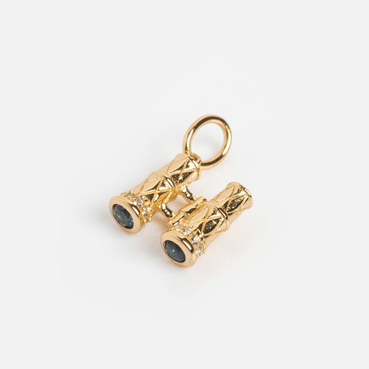 The Vintage Inspired Trinket Charm is a small gold vermeil binocular-shaped charm with engraved details and dark lenses, featuring a top loop for attaching to a necklace or bracelet, shown against a white background.