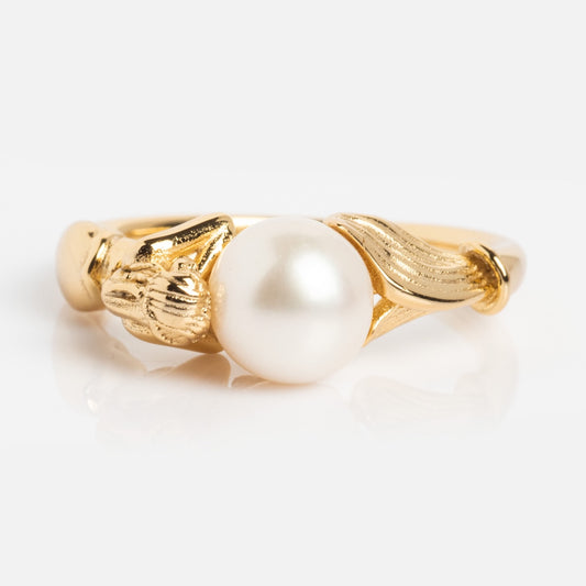 The Pearl Siren Statement Ring features a central white pearl with intricate gold leaf and floral accents, displayed on a plain white background.