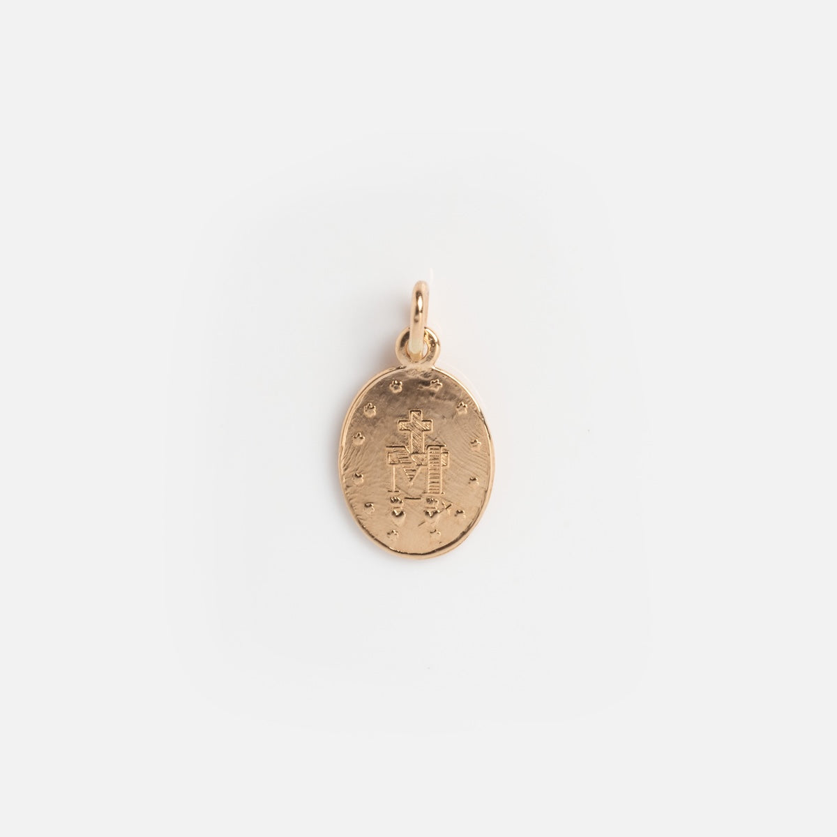 The Vintage 14k Miraculous Medal Charm is a small, oval-shaped gold piece with an embossed cross and decorative details, featuring a top loop for chains—a timeless accessory for vintage jewelry enthusiasts.