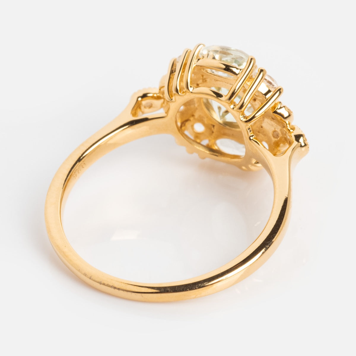 The Royal Gardens Green Amethyst Cocktail Ring features a 14k gold vermeil setting with an ornate band and prongs, holding a large faceted green amethyst, shown from the side to highlight its intricate design.