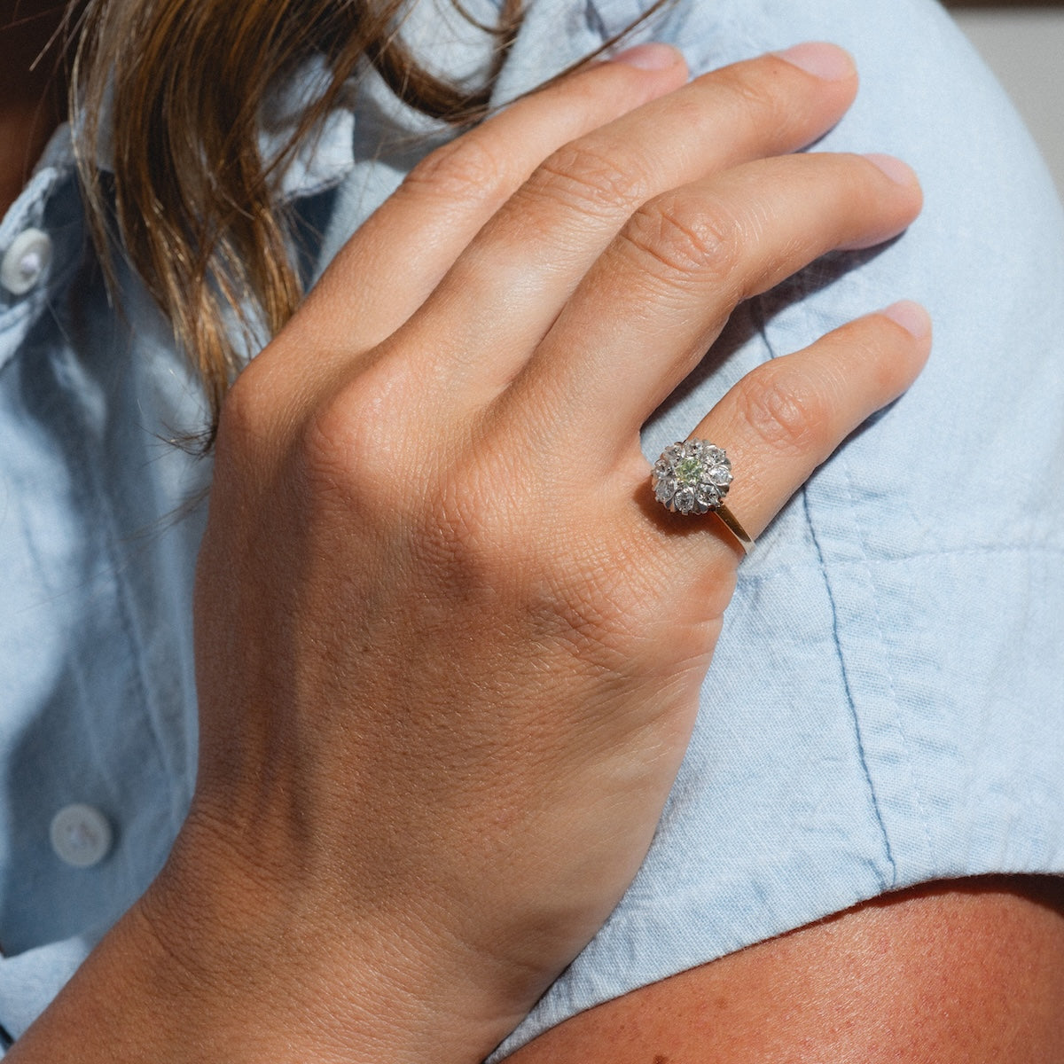 A woman wearing a Vintage 14k 1920s Euro Cut Diamond Cluster Ring, size 5, set in yellow gold.