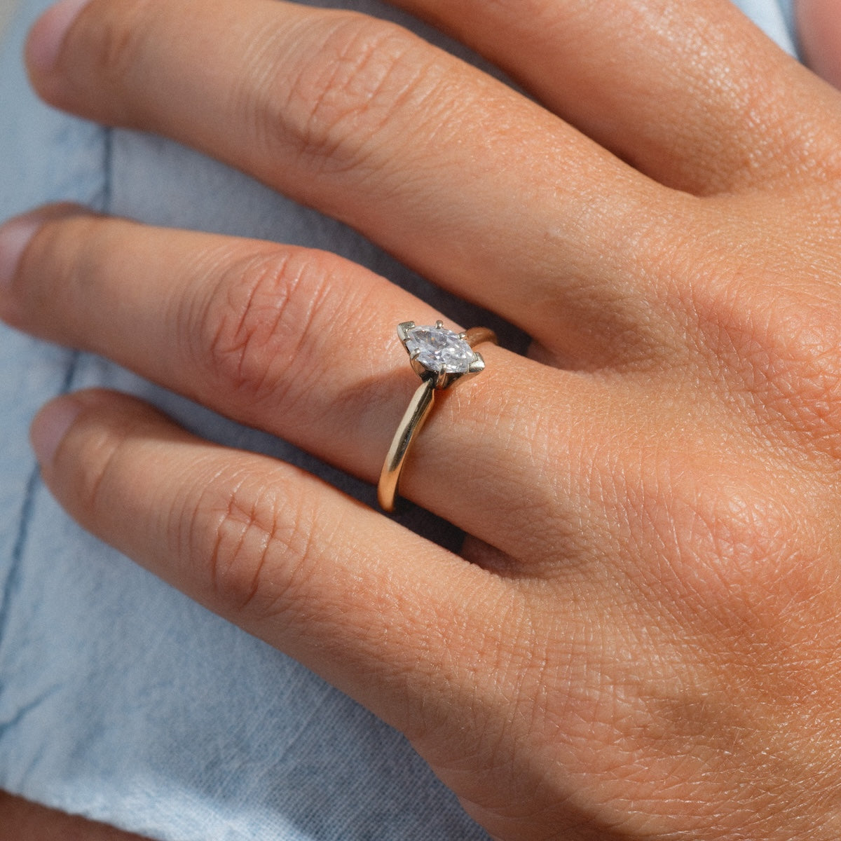 A person wearing a Vintage 14k 1960s Solitaire Marquise Diamond Engagement Ring, size 7.