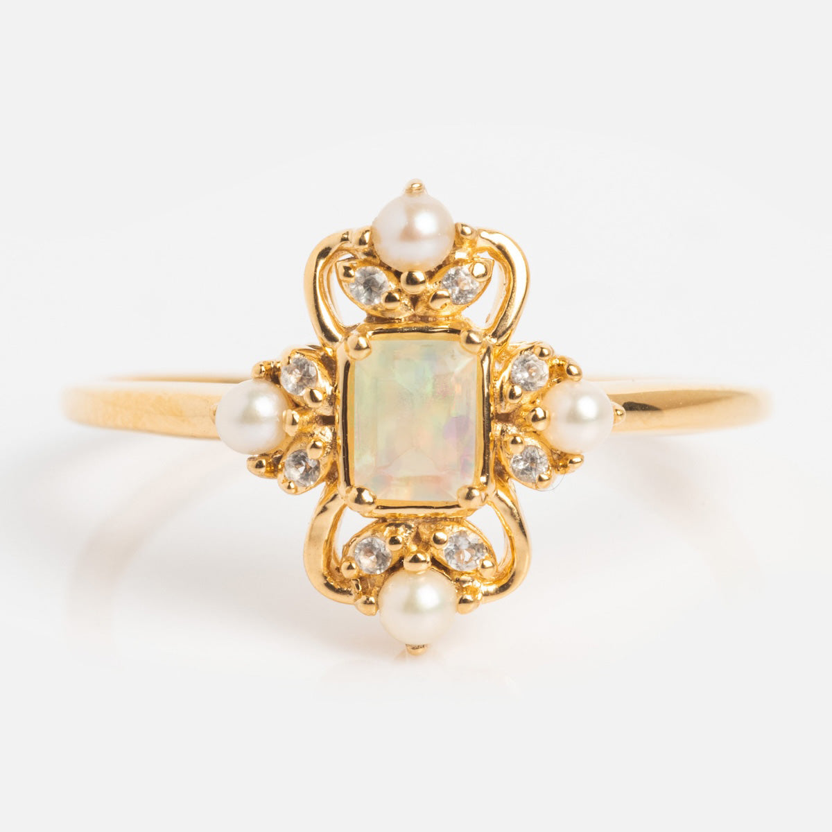 The Crown Jewel Opal and Pearl Ring is a 14k gold vermeil piece with a rectangular opal center, framed by pearls and diamonds in an ornate, vintage-inspired setting, shown against a plain white background.