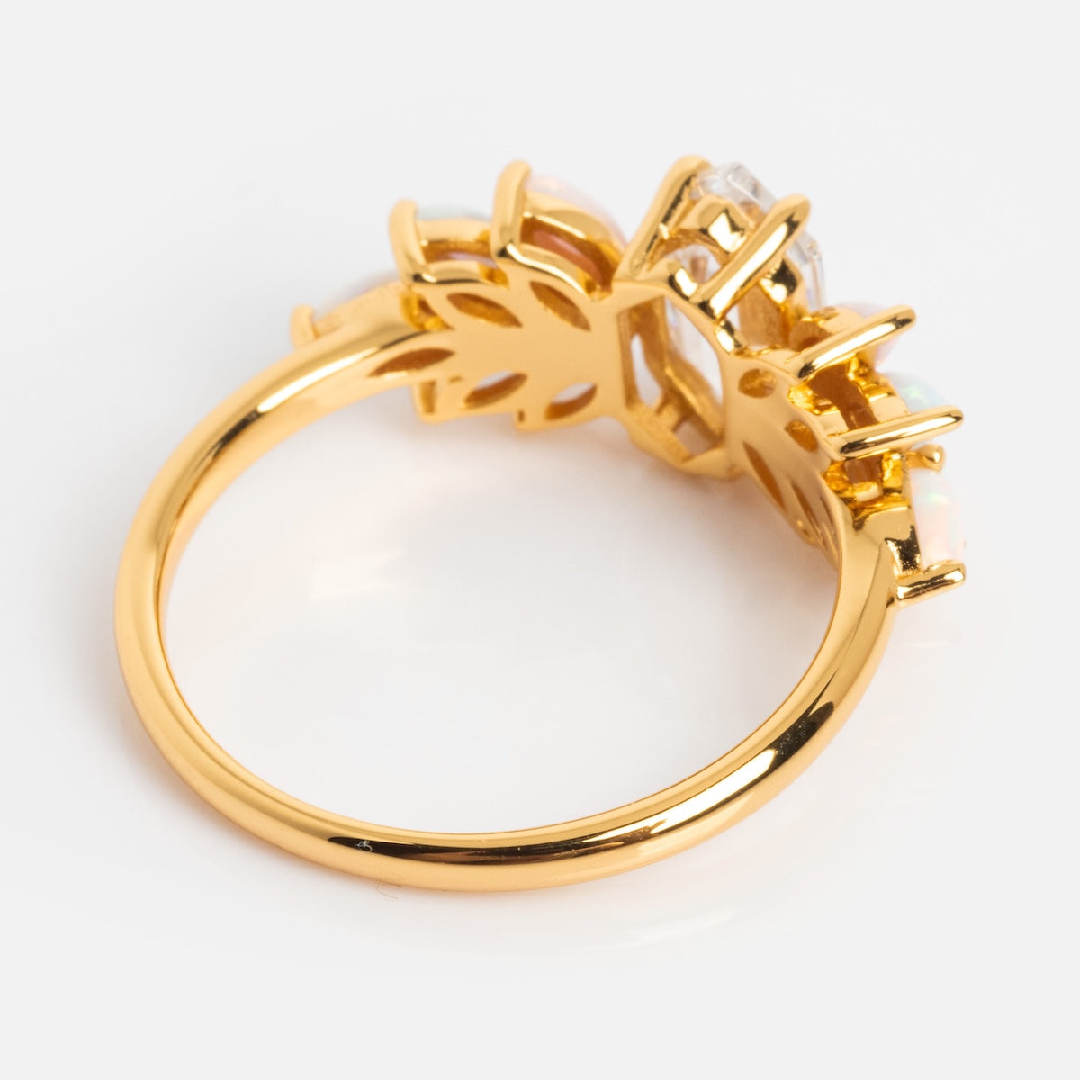 The Pink Opal Ombre and Topaz Lotus Ring, crafted in 18k Gold Vermeil, features multiple small oval pink opals and topaz set in a decorative lotus design. Shown from the side on a white background.