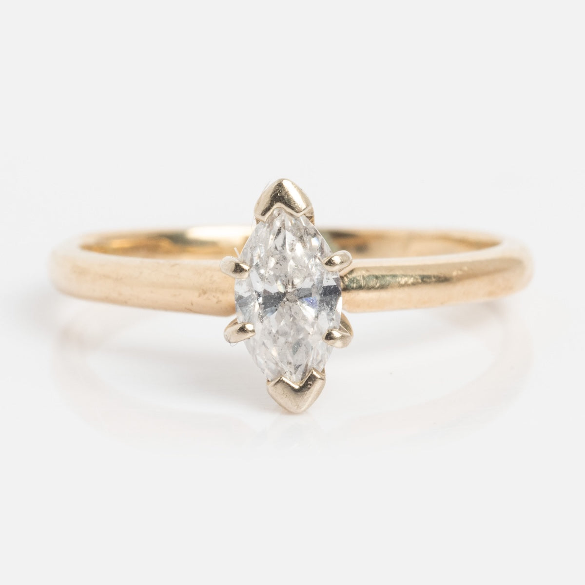 The Vintage 14k 1960s Solitaire Marquise Diamond Engagement Ring, size 7, features a marquise-cut diamond in a simple four-prong setting, showcased against a plain white background.