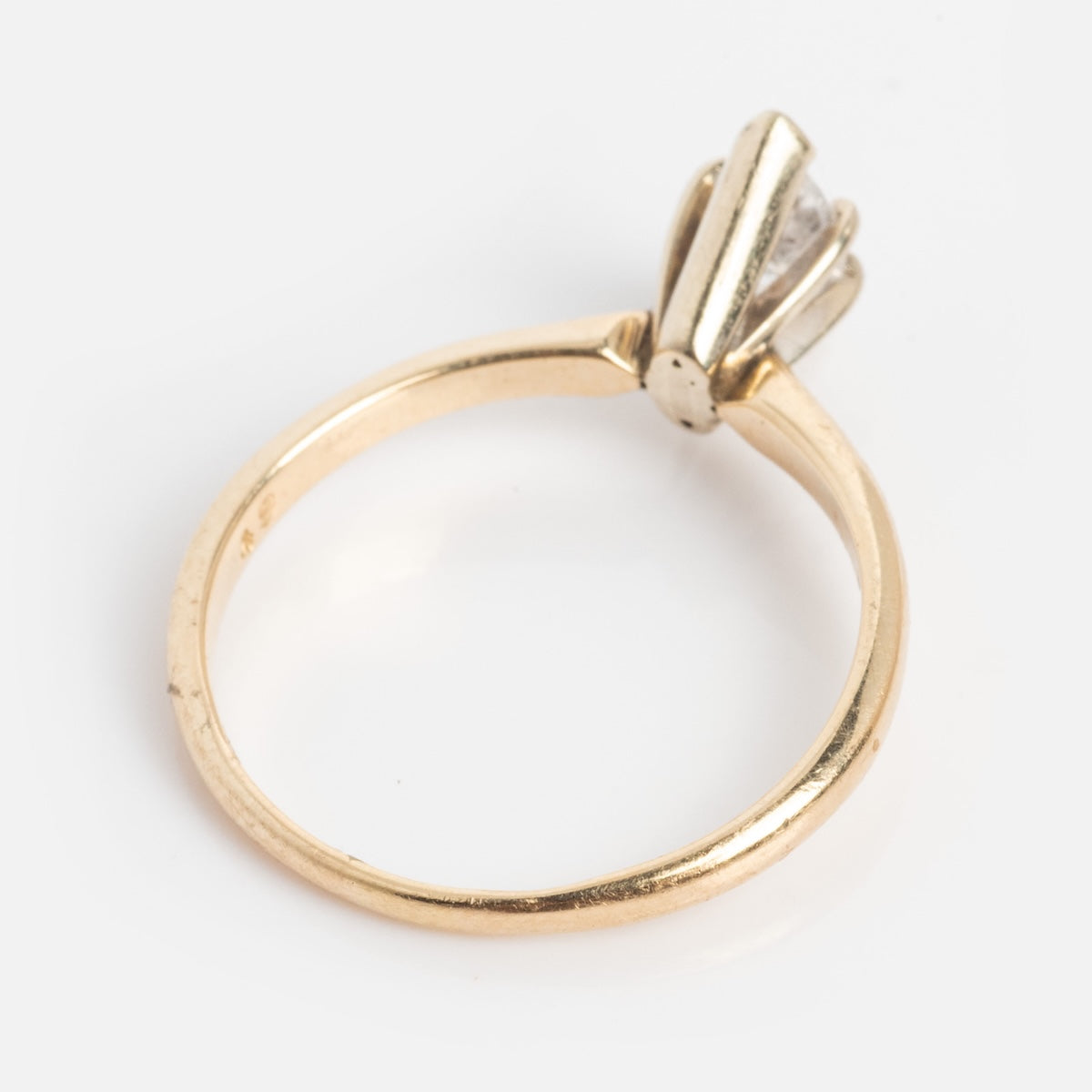 A vintage 14k gold 1960s solitaire marquise diamond engagement ring, size 7, is showcased against a plain white background.