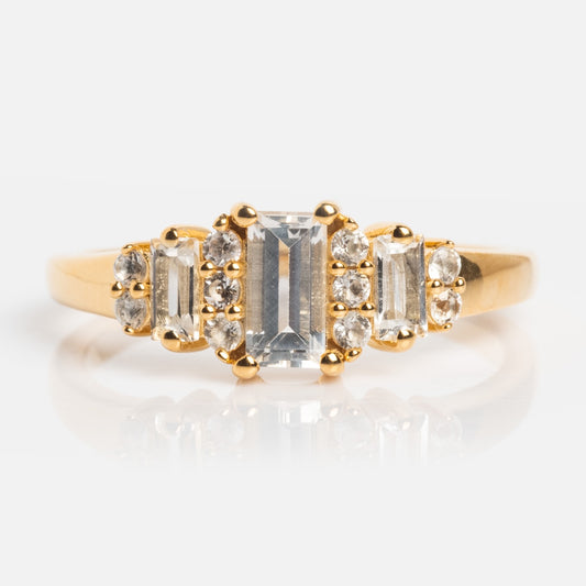 The Third Act Art Deco Ring showcases a rectangular center stone flanked by two smaller gems and clusters of round diamonds, all set on a polished 14k gold vermeil band with vintage-inspired design.