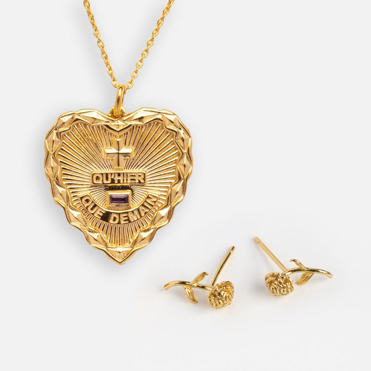 The Valentines Day Hearts and Flowers Gift Set features a gold heart pendant necklace with a sunburst design and French text, paired with delicate rose-shaped birth flower earrings, all displayed on a white background.
