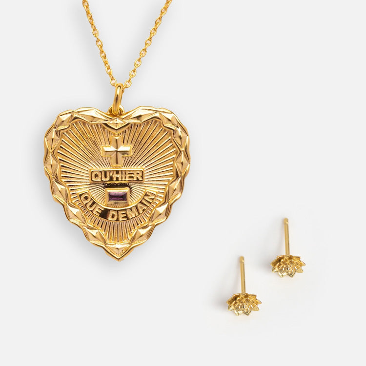 The Valentines Day Hearts and Flowers Gift Set features a gold heart pendant necklace with a sunburst and French words, plus small gold birth flower earrings, all displayed on white—a beautiful jewelry gift set.