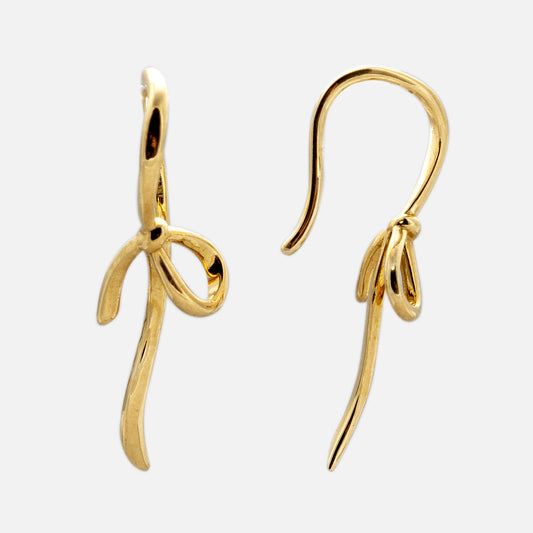 The Solid Gold Knot Drop Earrings are crafted in 9k yellow gold, featuring abstract bow-shaped dangles with a knotted design, smooth curves, and a shiny finish, displayed on a plain white background.