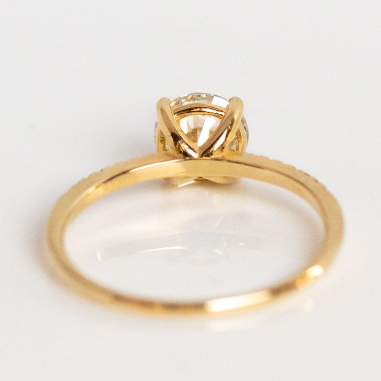 A 9kt Round Cut Diamond Solitaire Engagement Ring with Pave Diamond Band, sample size 7, displayed from a side angle on a white background.