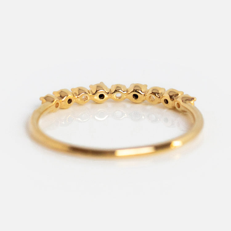 The 14k Classic White Sapphire and Black Diamond Band features a delicate yellow gold band with crown-like accents along the top, showcased against a white background.