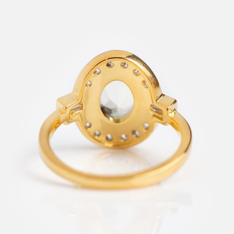 An Oval Deco Green Amethyst and CZ Ring in gold vermeil features a round bezel setting with a central green amethyst, surrounded by small dots, shown from the back on a white background.