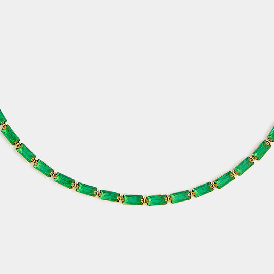 A partial view of the Duomo Emerald Green Necklace, featuring rectangular green stones evenly spaced along a gold-plated chain, displayed on a plain white background.
