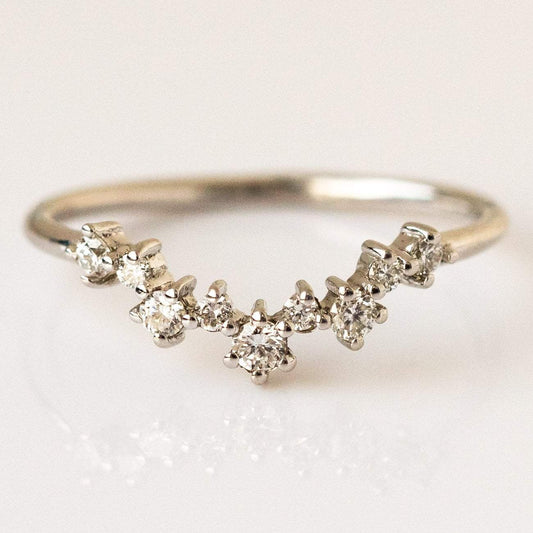 The Aster Diamond Cluster Band in White Gold (Sample Size 4) features a curved 14K white gold band set with seven ethically sourced round diamonds in a gentle arc, with the center stone slightly larger than the others.