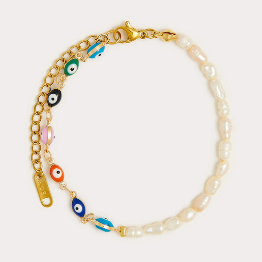 The Evil Eye Pearl Bracelet features small white freshwater pearls, multicolored evil eye beads, and a gold-plated chain with a lobster clasp and extender.