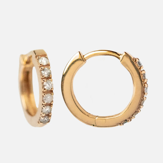 The Solid Gold Diamond Huggie Hoops Sample features small 10k yellow gold hoops, each with a row of round brilliant cut diamonds on the front. This Local Eclectic exclusive is shown on a white background.