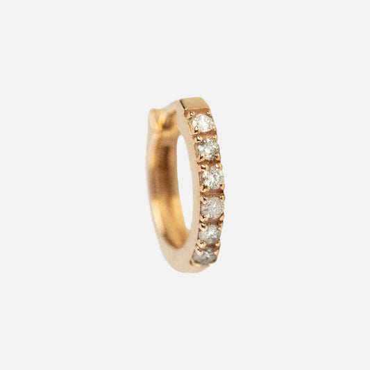 The Solid Gold Diamond Huggie Hoop Single is a 12mm diameter earring in 10k yellow gold, featuring seven round brilliant cut diamonds on the front, displayed on a plain white background.