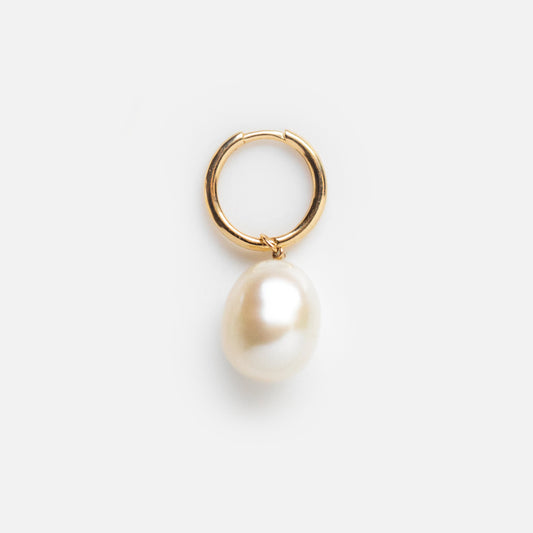 The Solid Gold Elegant Pearl Charm Huggies are gold huggie hoop earrings with a large removable pearl charm, shown against a plain white background.